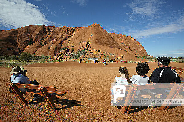 Touristen beobachten  wie Menschen den Uluru besteigen  früher bekannt als Ayers Rock; Northern Territory  Australien