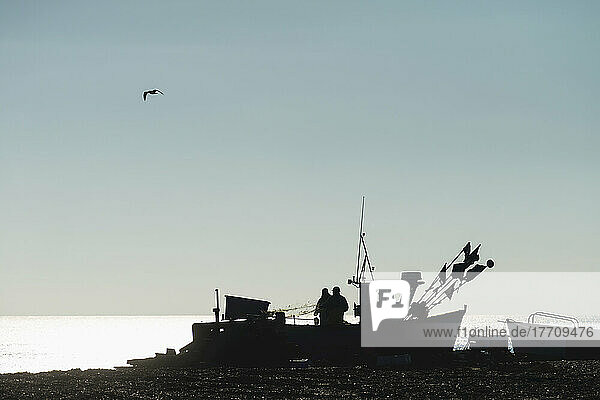 Fishermen Sorting Out Their Nets On Boat On Aldeburgh Beach; Suffolk  England