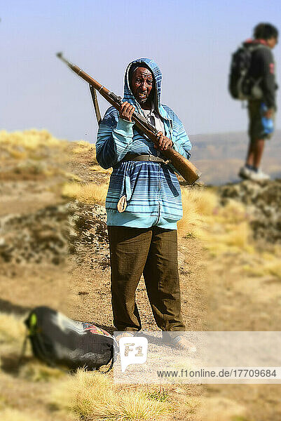 Ein Hausbesetzer steht mit einem Gewehr und schaut in die Kamera im Simien-Nationalpark in Äthiopien; Äthiopien