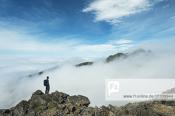 Ein Wanderer bewundert die Aussicht vom Gipfel des Sgurr Nan Eag  einem der Gipfel der Black Cuillin; Isle Of Skye  Schottland