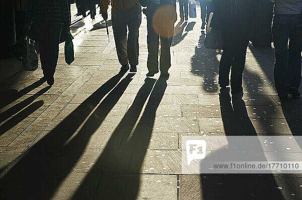 Schatten von Fußgängern auf dem Bürgersteig; London  England