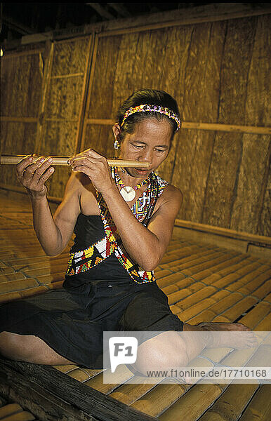 Runggus Woman Playing Nose Flute In A Long House  Sabah  Borneo  Malaysia