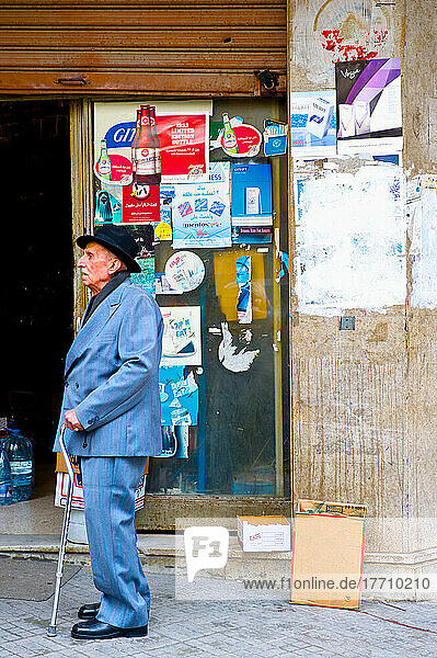 Ein älterer Herr mit einem Gehstock geht auf einer städtischen Straße; Beirut  Libanon