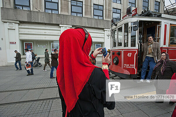 Eine Frau mit Kopftuch fotografiert einen Mann in einer Straßenbahn; Istanbul  Türkei