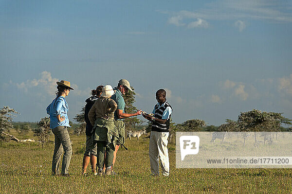 Führer zeigt Menschen Kieferknochen eines Tieres auf Wandersafari  Ol Pejeta Conservancy; Kenia