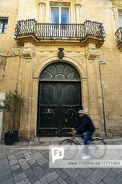 Ein Mann fährt mit dem Fahrrad durch das historische Zentrum von Lecce  Italien; Lecce  Apulien  Italien