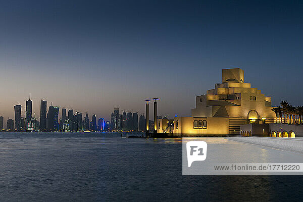Museum für Islamische Kunst in der Abenddämmerung mit moderner Stadtsilhouette dahinter; Doha  Katar