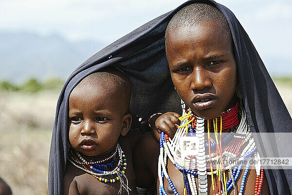Ein junger Mann und ein kleines Kind tragen bunten Perlenschmuck; Omo-Tal  Äthiopien