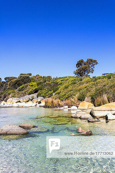 Eine junge Frau schwimmt am Bay Of Fires Beach; Tasmanien  Australien