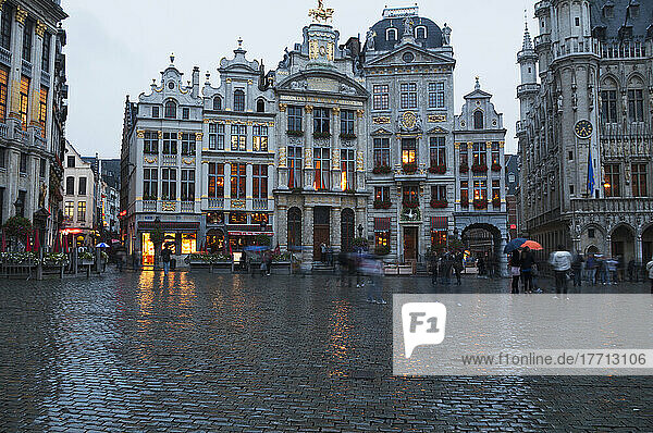 Fußgänger  die durch einen nassen Stadtplatz gehen; Brüssel  Belgien