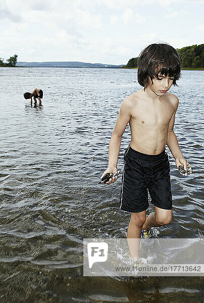4 und 6 Jahre alt  die im Wasser spielen und Muschelschalen sammeln; Montreal  Quebec  Kanada