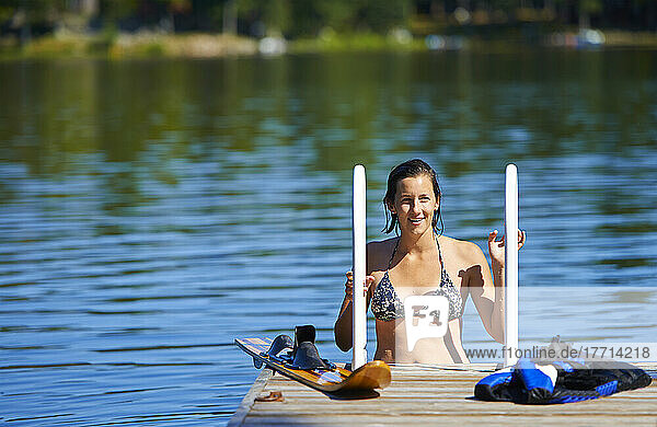 22-jähriges Mädchen auf Dock-Leiter im Wasser mit Wasserski; Ontario  Kanada