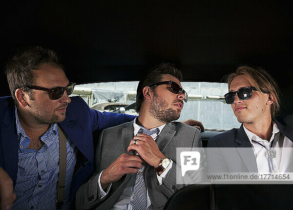 Three Businessmen Sitting In The Backseat Of A Car; Langley  British Columbia  Canada