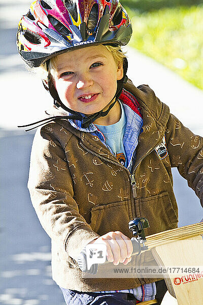 Junger Junge auf einem Fahrrad und lächelnd.