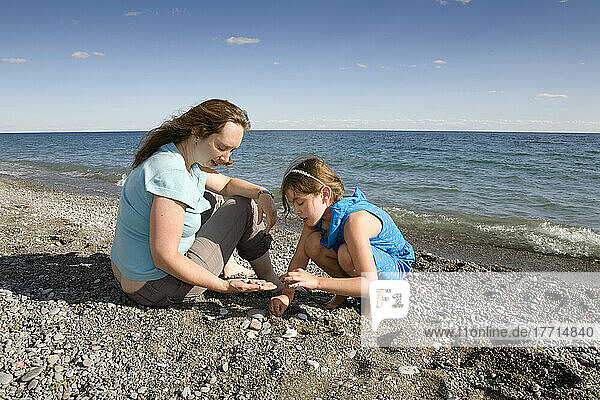 Mutter und Tochter beim Steinesammeln am Ufer des Ontariosees; Ontario  Kanada