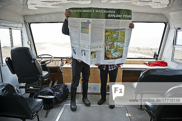 Zwei Menschen  die eine Karte auf einem Tundra-Buggy betrachten; Churchill  Manitoba  Kanada