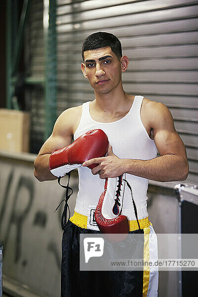 A Young Man Putting On Boxing Gloves; San Francisco  California  USA