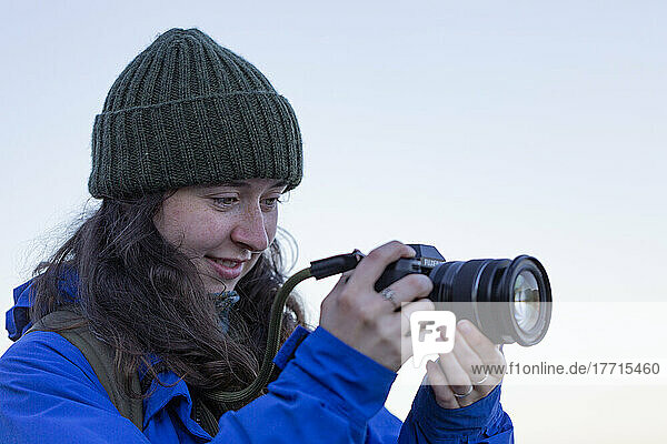 Junge Frau beim Fotografieren in der freien Natur mit Digitalkamera und Objektiv im Whytecliff Park  Horseshoe Bay; British Columbia  Kanada