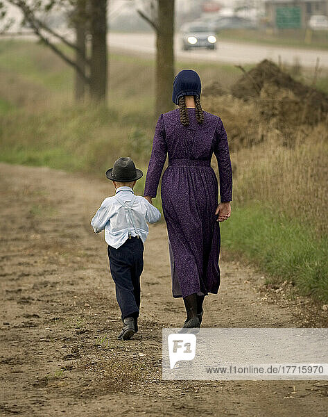 Frau und Junge gehen auf einer unbefestigten Straße  Elmira  Ontario