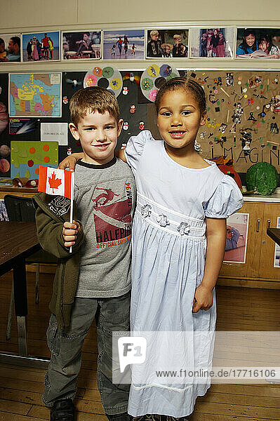 Sieben Jahre alter Junge und Mädchen mit kanadischer Flagge in der Schule Klassenzimmer