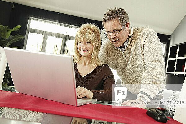 Mann und Frau schauen auf Laptop
