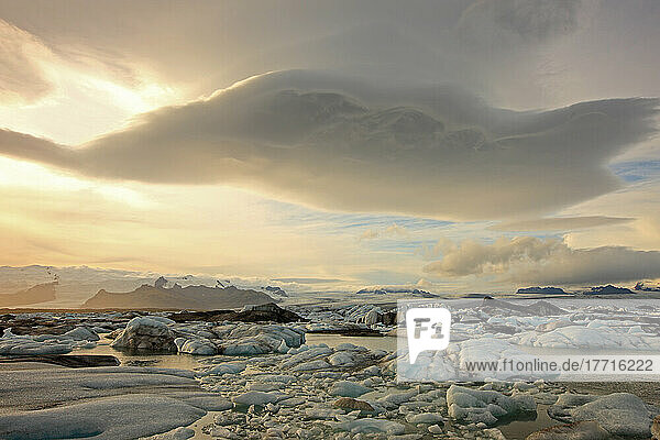 Die schmelzenden Eisberge von Jokulsarl auf der Gletscherlagune in Südisland mit linsenförmigen Wolken über ihnen