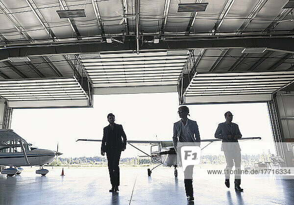 Three Businessmen Entering Airplane Hangar; Langley  British Columbia  Canada
