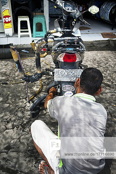 Indonesischer Mann repariert eine Reifenpanne an seinem Motorrad  Bali  Indonesien