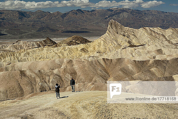 Wanderer  der ein Foto in den Badlands von Zabriskie Point im Death Valley National Park macht; Kalifornien Usa