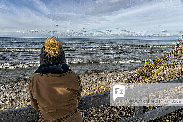 standing looking out over Lake Huron as the waves roll in endlessly; Grand Bend  Ontario  Canada