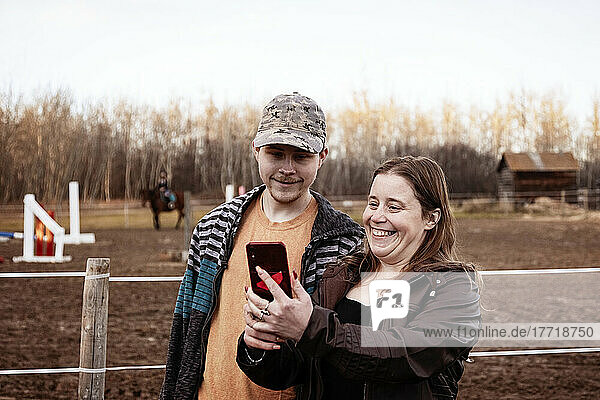 Eine Mutter mit Epilepsie macht ein Selbstporträt mit ihrem Sohn  der das Aspberger-Syndrom hat  in einem Pferdezentrum; Westlock  Alberta  Kanada