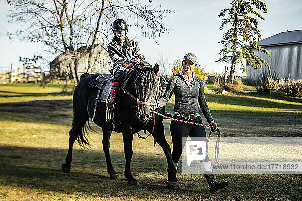 Ein junges Mädchen mit Cerebralparese und ihr Trainer arbeiten mit einem Pferd während einer Hippotherapie-Sitzung; Westlock  Alberta  Kanada
