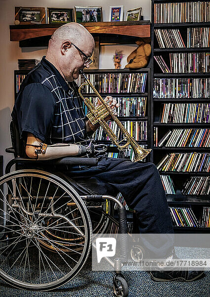 Mann mit doppelter Gliedmaßenamputation spielt zu Hause Trompete; St. Albert  Alberta  Kanada