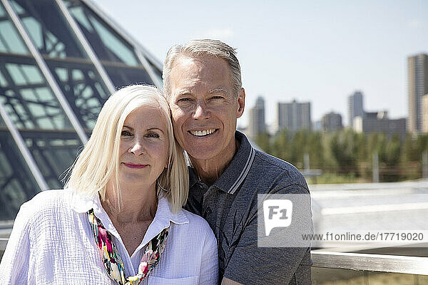 Outdoor portrait of a mature couple with a city skyline and architecture in the urban background; Edmonton  Alberta  Canada