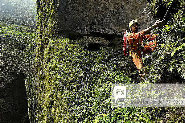 Ein Höhlenforscher klettert an einem dünnen Seil durch das Er Wang Dong-Höhlensystem.