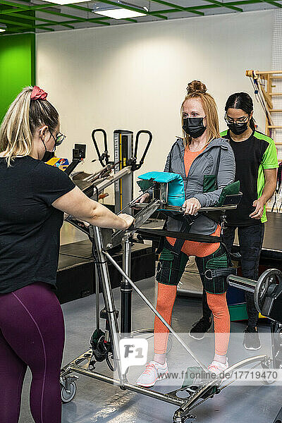 Eine querschnittsgelähmte Frau trainiert mit ihren Trainern an einem unterstützten Gehgerät; Edmonton  Alberta  Kanada