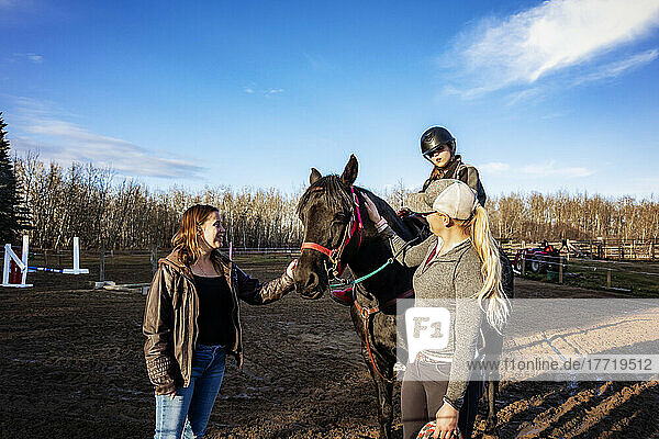 Ein junges Mädchen mit Cerebralparese  ihre Mutter und ihr Trainer arbeiten mit einem Pferd während einer Hippotherapie-Sitzung; Westlock  Alberta  Kanada