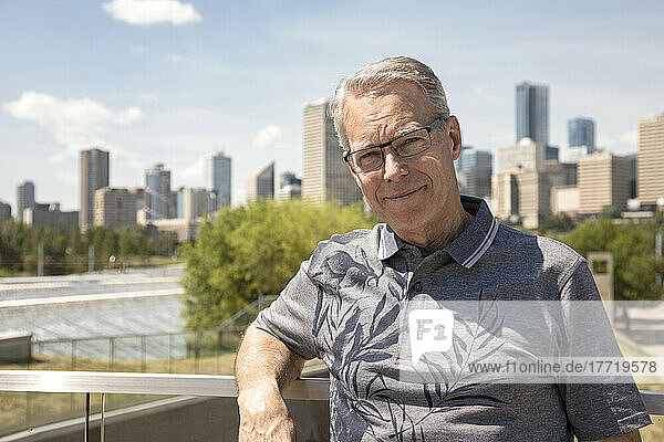 Außenporträt eines älteren Mannes mit Brille  Skyline der Stadt im Hintergrund; Edmonton  Alberta  Kanada