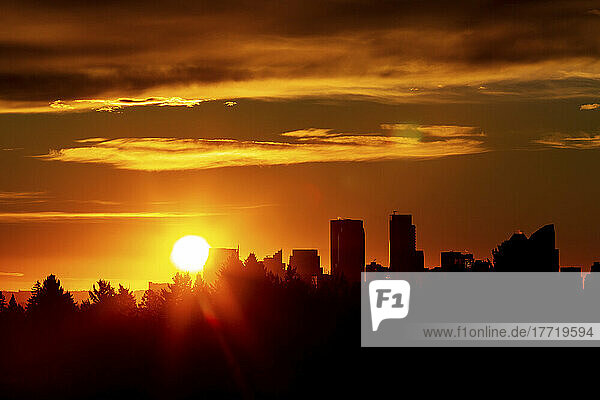 Dramatischer  farbenfroher Himmel mit einer Silhouette der Stadt und einem Sonnenaufgang; Calgary  Alberta  Kanada