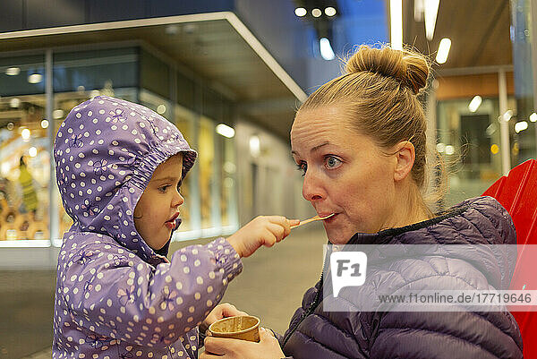Mutter und kleine Tochter teilen sich einen Snack am Lonsdale Quay  North Vancouver; North Vancouver  British Columbia  Kanada