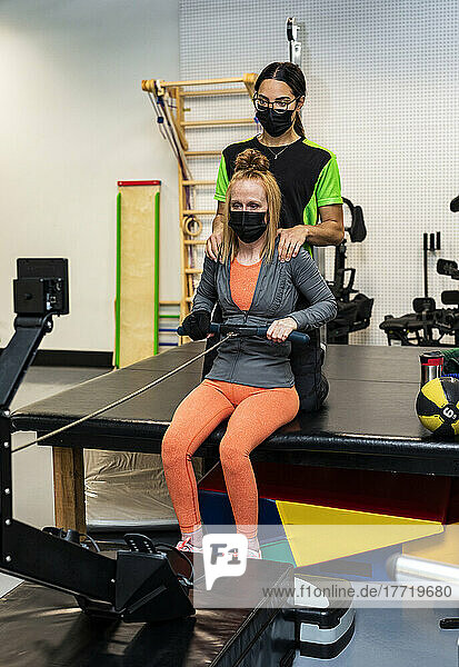 Eine querschnittsgelähmte Frau trainiert mit ihrem Trainer an einem Rudergerät; Edmonton  Alberta  Kanada