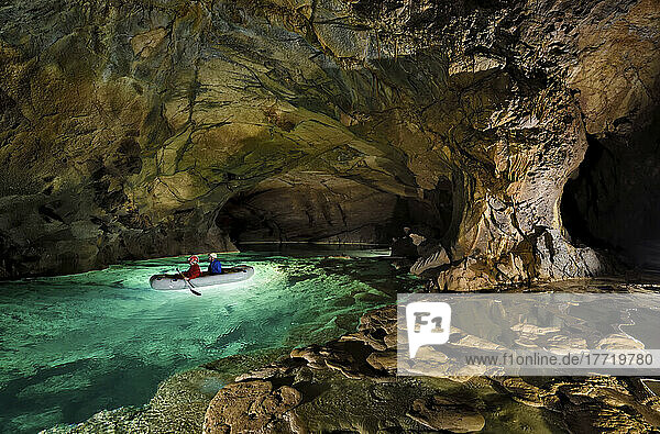Forscher paddeln auf einem See in der Krizna jama  der Kreuzhöhle.