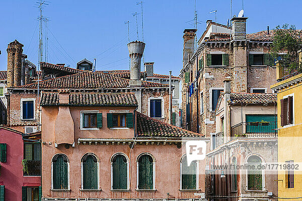Traditional Venetian buildings in a colourful setting under a blue sky; Venice  Veneto  Italy