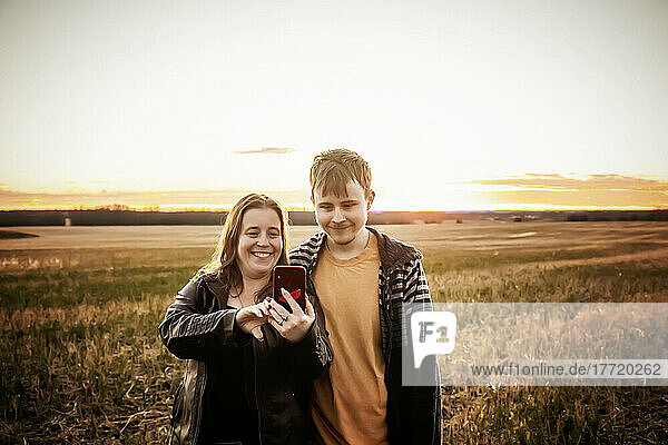 Eine Mutter mit Epilepsie macht ein Selbstporträt mit ihrem Sohn  der am Aspberger-Syndrom leidet  auf einem Feld auf einer Farm nach der Ernte; Westlock  Alberta  Kanada