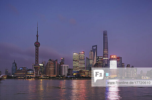 Ein Blick in der Abenddämmerung auf den Stadtteil Pudong  über den Huangpu-Fluss hinweg vom Bund aus gesehen  Shanghai  China; Shanghai  China