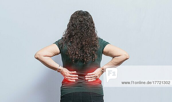 Person mit Wirbelsäulenproblemen  Frau mit Rückenproblemen auf isoliertem Hintergrund  Konzept einer Frau mit Lendenproblemen  eine wunde Frau mit Rückenschmerzen