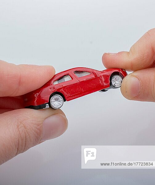 Kind verschenkt Spielzeugauto auf weißem Hintergrund