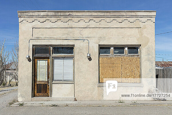 Abandoned building facade  boarded up windows and stonework pattern.