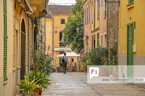 Woman walking down narrow street in the old town of Alcudia  Alcudia  Majorca  Balearic Islands  Spain  Mediterranean  Europe