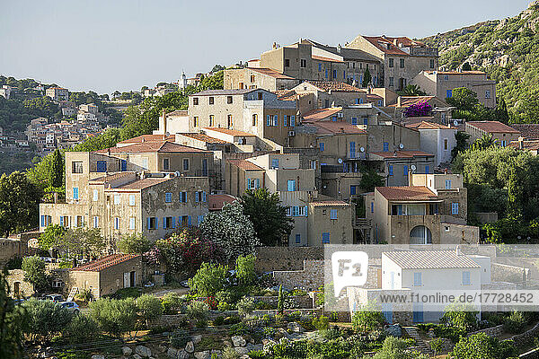 Village houses perched on steep hillside  Corbara in background  Pigna  L'Ile-Rousse Balagne  Haute-Corse  Corsica  France  Mediterranean  Europe